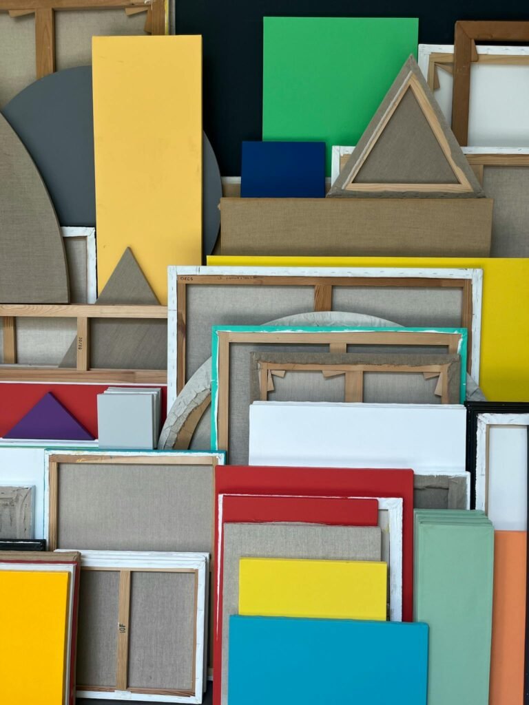 Vibrant collection of assorted geometric canvas frames in an artistic studio setting.